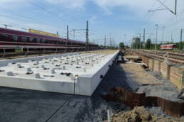 ARA-Gleiswanne aus Beton auf einer Baustelle neben Gleisen, zur Sammlung wassergefährdender Flüssigkeiten bei Schienenfahrzeugen.