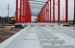 Abbildung einer Gleis-Tragwanne im Au&szlig;enbereich, deren Funktion es ist, wassergef&auml;hrdende Fl&uuml;ssigkeiten aufzufangen. Im Vordergrund ist die Betonunterkonstruktion der Wanne zu sehen.