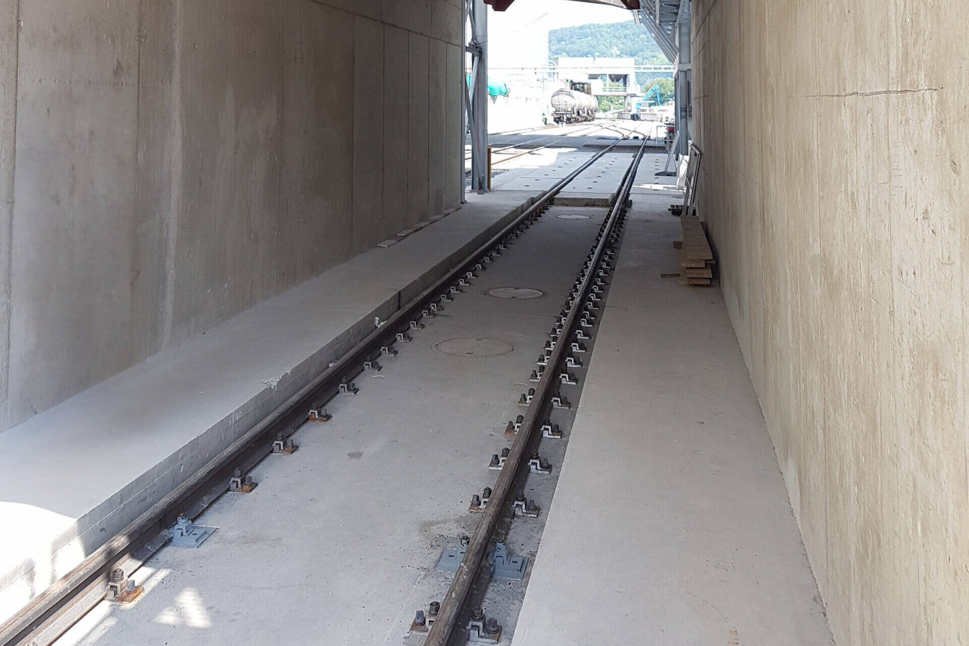 Ansicht einer Gleis-Waagenbrücke, verbaut in einem Tunnel. Die Gleiswaagen ermöglichen die genaue Gewichtsermittlung und tragen dadurch zur Sicherheit von Transportvorgängen bei.