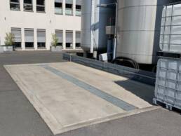 LKW-Tragwanne auf Industriegel&auml;nde, mit mittigem Ablauf. Sie f&auml;ngt wassergef&auml;hrdende Stoffe auf und leistet damit einen wichtigen Beitrag zum Umweltschutz.