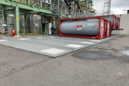 Die Abbildung zeigt mehrere LKW-Tragwannen nebeneinander, die dem Auffangen von Chemikalien im Industriebereich dienen.